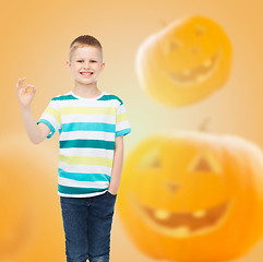Image showing smiling boy over pumpkins background