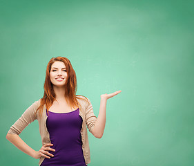 Image showing smiling teenage girl holding something on her palm