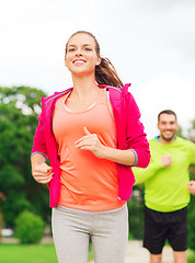 Image showing smiling couple running outdoors