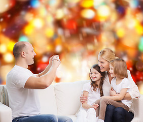 Image showing happy family with camera at home