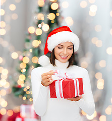 Image showing smiling woman in santa helper hat with gift box