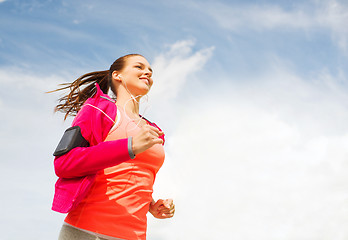 Image showing smiling young woman running outdoors