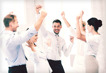 Image showing business team celebrating victory in office