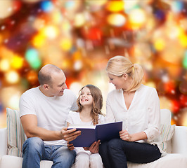 Image showing happy family with book at home