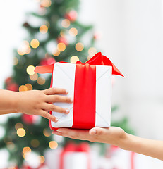 Image showing close up of child and mother hands with gift box