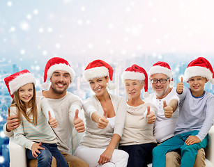 Image showing happy family in santa hats showing thumbs up