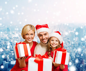 Image showing happy family in santa helper hats with gift boxes