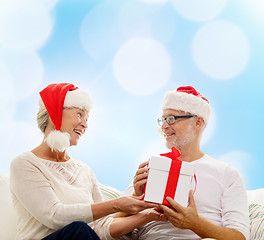 Image showing happy senior couple with gift box at home