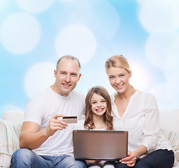 Image showing happy family with laptop computer and credit card