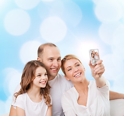 Image showing happy family with camera at home