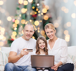 Image showing happy family with laptop computer and credit card