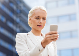 Image showing serious businesswoman with smartphone outdoors