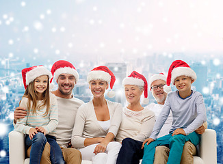 Image showing happy family in santa helper hats sitting on couch