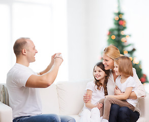 Image showing happy family with camera at home