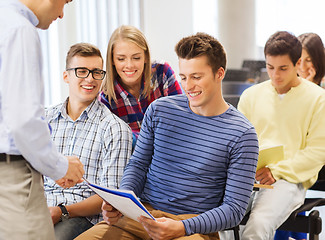 Image showing group of students and teacher with notebook