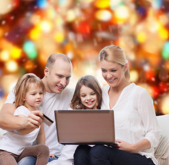 Image showing happy family with laptop computer and credit card