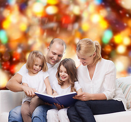 Image showing happy family with book at home