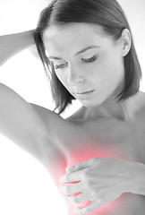 Image showing woman checking breast for signs of cancer