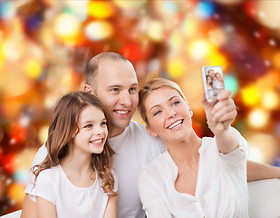 Image showing happy family with camera at home