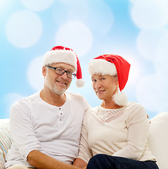 Image showing happy senior couple in santa helper hats