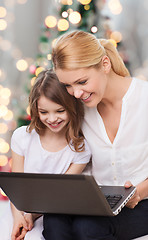 Image showing smiling mother and little girl with laptop