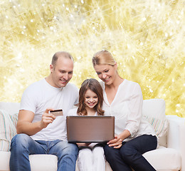 Image showing happy family with laptop computer and credit card