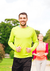 Image showing smiling couple running outdoors