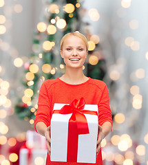 Image showing smiling woman in red clothes with gift box