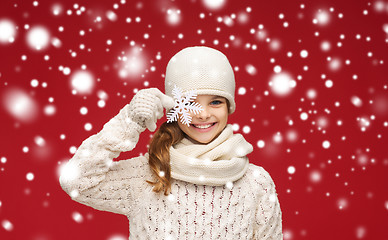 Image showing smiling girl in winter clothes with big snowflake