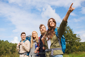 Image showing group of smiling friends with backpacks hiking