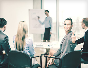 Image showing businesswoman with team showing thumbs up