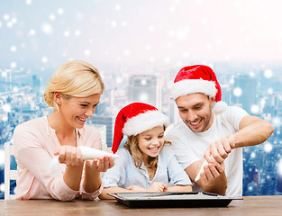 Image showing happy family in santa helper hats cooking