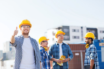 Image showing group of smiling builders in hardhats outdoors