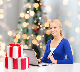 Image showing smiling woman with credit card and laptop