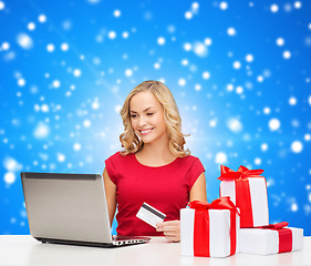 Image showing smiling woman with credit card and laptop