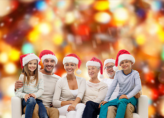 Image showing happy family in santa helper hats sitting on couch