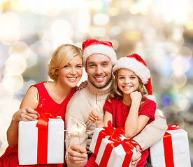 Image showing happy family in santa helper hats with gift boxes