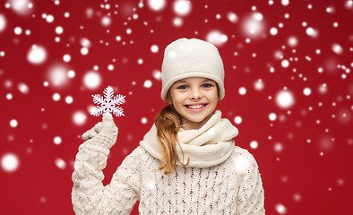 Image showing smiling girl in winter clothes with big snowflake