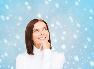 Image showing thinking and smiling woman in white sweater