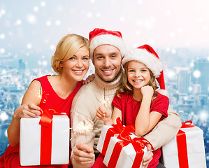 Image showing happy family in santa helper hats with gift boxes