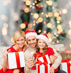 Image showing happy family in santa helper hats with gift boxes