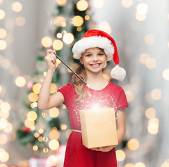 Image showing smiling girl in santa helper hat with gift box