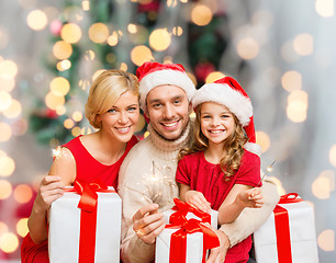 Image showing happy family in santa helper hats with gift boxes