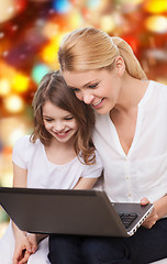 Image showing smiling mother and little girl with laptop