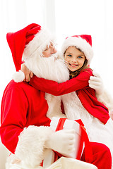 Image showing smiling girl with santa claus and gift at home