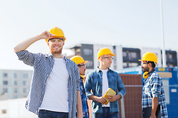 Image showing group of smiling builders in hardhats outdoors