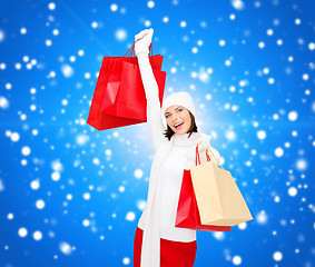 Image showing smiling young woman with red shopping bags