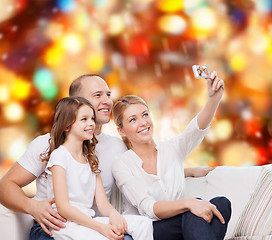 Image showing happy family with camera at home