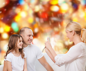 Image showing happy family with camera at home