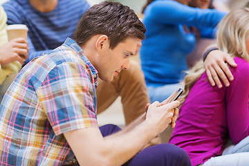 Image showing group of smiling students with smartphone